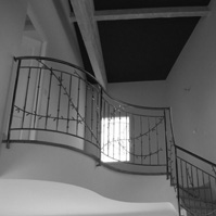 Photo intérieure : escalier, garde corps en ferronerie, charpente bois apparente.<br />