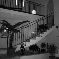 Escalier intérieur carrelé avec garde corps en fer forgé.<br />