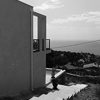 Vue de la façade Ouest de la villa avec escaliers menant à la piscine et au bas du jardin<br />